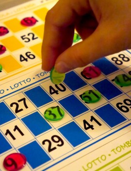 mains d'enfant indiquant grâce à son  jetons de marquage, le chiffre 40 tiré au sort lors d'une partie de bingo