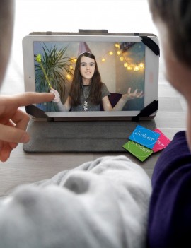 Des enfants regardent la vidéo de Félicie sur une tablette, chasse au trésor interactive