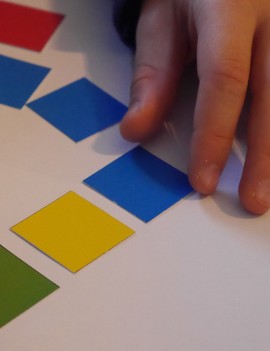 mains d'enfants jouant au Mémo couleurs, objectif reconstituer une série de carré de couleur observé précédement